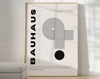 Può includere: Un poster in bianco e nero con il testo "Bauhaus Modern Art" e un design geometrico. Il poster è incorniciato in una cornice dorata e appeso a un muro bianco.