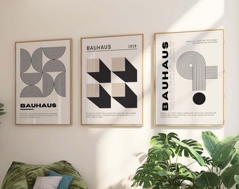 Può includere: Tre stampe d'arte geometriche in bianco e nero con il testo "Bauhaus 1919" su una parete bianca sopra una poltrona sacco di velluto verde e due divani bianchi.