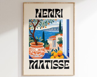 Può includere: Una stampa incorniciata di un dipinto di Henri Matisse. Il dipinto raffigura un albero di arancio in vaso con vista su un mare blu e un edificio bianco sullo sfondo. Il testo "HENRI MATISSE" è stampato in nero nella parte superiore e inferiore dell'immagine.