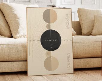 Può includere: Una stampa d'arte geometrica beige e marrone con le parole "Modern Bauhaus" in orientamento verticale. La stampa presenta un cerchio nero con cerchi bianchi più piccoli all'interno, circondato da cerchi concentrici e due cerchi beige.