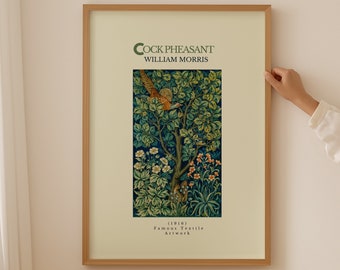 Può includere: Una stampa incorniciata di un design tessile vintage con un fagiano in un albero con foglie verdi e fiori bianchi e arancioni. Il titolo dell'opera d'arte è "Cock Pheasant" di William Morris. Il testo sotto l'immagine recita "1896, Famous Textile Artwork."