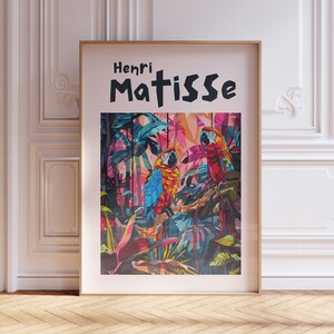 May include: A framed poster with a colorful illustration of two parrots in a jungle setting. The poster features the text "Henri Matisse" in black lettering.