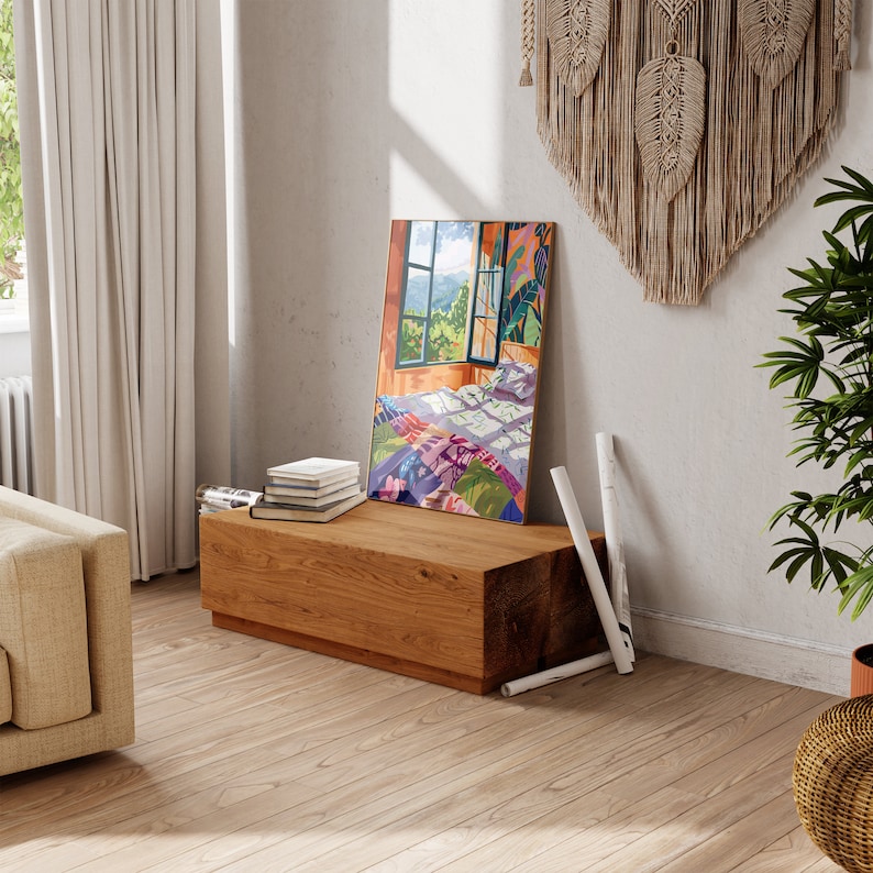 May include: A wooden bench with a stack of books on top. The bench is in a room with a window and a painting of a bedroom with a colorful quilt on the bed.