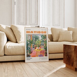 May include: A poster with a colorful painting of a garden scene with a table and chairs. The poster is titled "Matisse" and has the text "Tribute to a Master" and "Explore Matisse's World" at the bottom. The poster also includes the text "06200 Nice, France".
