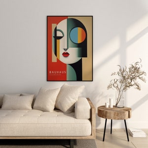 Puede incluir: Un p&oacute;ster enmarcado con un dise&ntilde;o geom&eacute;trico en tonos de rojo, negro, blanco, azul y amarillo. El p&oacute;ster presenta una cara estilizada con un solo ojo y el texto "BAUHAUS 1919 EXHIBITION ART".
