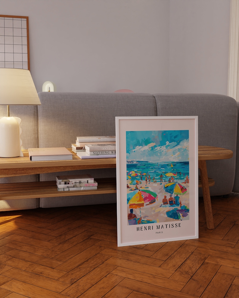 May include: A framed print of a colorful painting by Henri Matisse depicting a beach scene with people and umbrellas. The painting is titled "Henri Matisse, Paris".