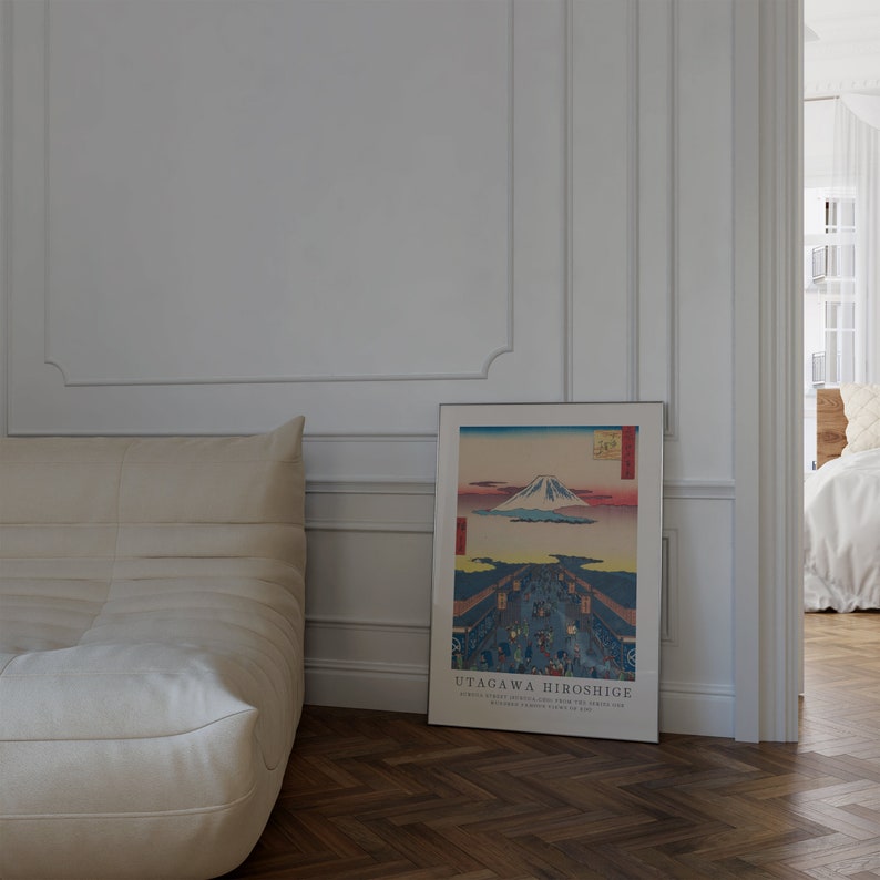 May include: A white couch with a framed print of a Japanese landscape featuring Mount Fuji. The print is titled "UTAGAGAWA HIROSHIGE" and includes the text "Thirty-six Views of Mount Fuji, "The Great Wave off Kanagawa" and "The Summit of Mount Fuji, as seen from the Lake of Hakone".