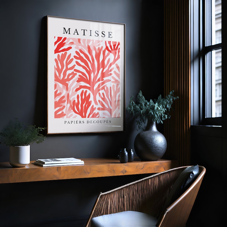 Op de afbeelding: Een ingelijste print van een Matisse-kunstwerk met een rood koraalontwerp met de tekst "MATISSE PAPIERS DECOUPES".