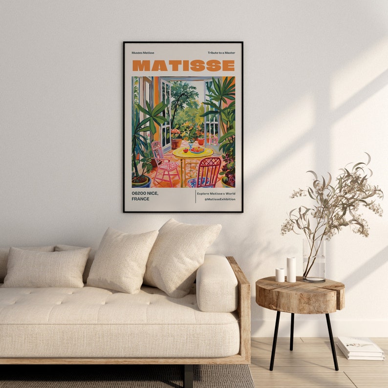 May include: A colorful poster with the text "MATISSE" in orange letters. The poster features a painting of a patio with a table and chairs, surrounded by lush greenery. The text "06200 NICE, FRANCE" is at the bottom left corner of the poster.