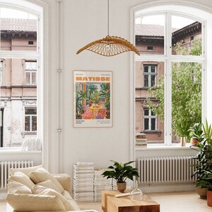 May include: A poster with a colorful illustration of a garden scene with a table and chairs. The poster is titled "MATISSE" and features the text "Nice, France".