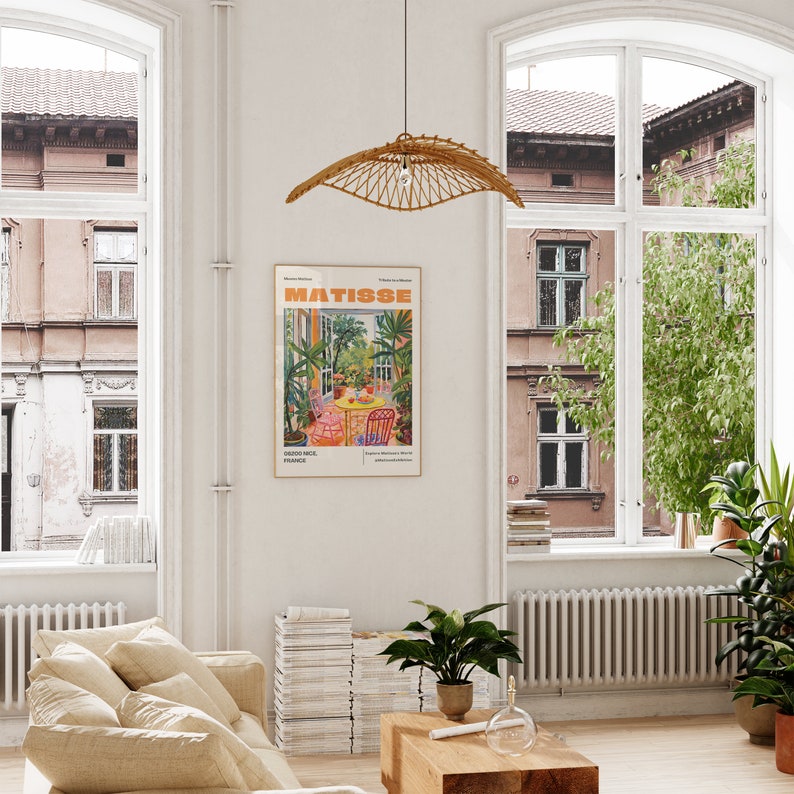 May include: A poster with a colorful illustration of a garden scene with a table and chairs. The poster is titled "MATISSE" and features the text "Nice, France".
