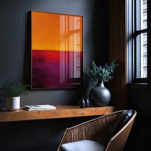 May include: A framed abstract art print with a gradient of orange and purple hues. The artwork hangs on a dark gray wall above a wooden desk. A decorative vase and chair are also visible in the room.