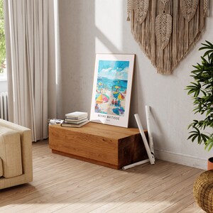 May include: A framed print of a beach scene with colorful umbrellas and people on the sand. The print is titled "Henri Matisse, Paris".