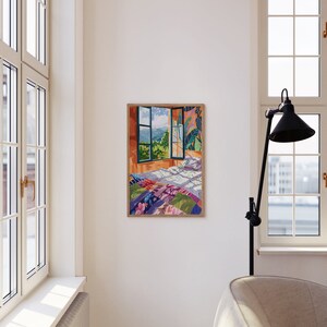 May include: A framed illustration of a bedroom with a bed covered in a colorful patchwork quilt. The bed is positioned in front of a window with a view of a green landscape.