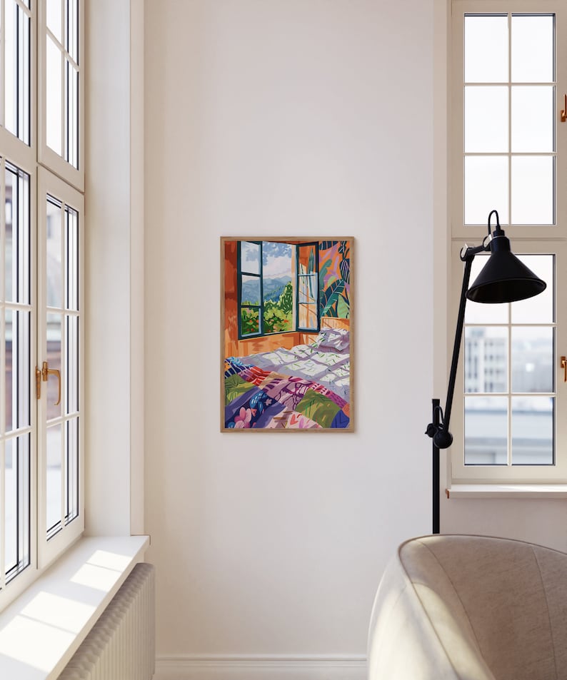May include: A framed illustration of a bedroom with a bed covered in a colorful patchwork quilt. The bed is positioned in front of a window with a view of a green landscape.