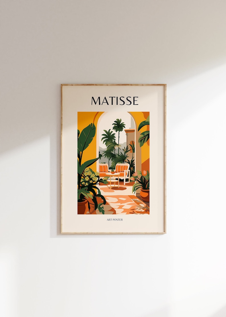 May include: A Matisse art poster featuring a yellow and orange color scheme. The poster depicts a patio with two chairs and a table, surrounded by lush green plants and palm trees. The text "MATISSE" is at the top of the poster, and "ART POSTER" is at the bottom.