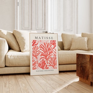 Op de afbeelding: Een poster met een rood en wit koraalontwerp. De poster heeft de tekst "MATISSE" en "PAPIERS DECOUPES" erop.