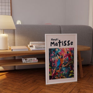 May include: A framed print of a painting by Henri Matisse featuring three colorful parrots in a jungle setting. The title of the painting is "Henri Matisse".