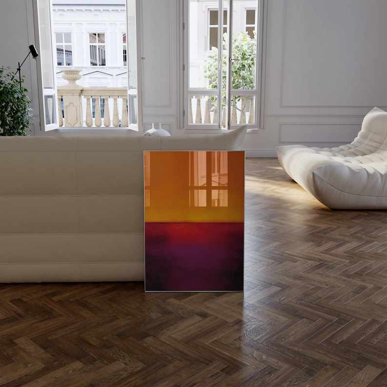 May include: An abstract art print featuring a gradient of colors. The top half transitions from orange to yellow, while the bottom half is a deep purple. The artwork is displayed in a modern living room setting.