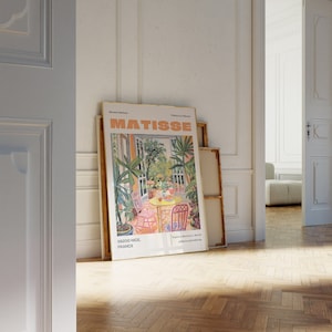 May include: A framed poster with a painting of a garden scene by Henri Matisse. The poster is titled "Matisse" and features the text "06200 Nice, France" and "Explore Matisse's World at MatisseEdition.com".