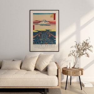 May include: A vintage Japanese woodblock print of Mount Fuji with a bustling street scene in the foreground. The print is titled "Utagawa Hiroshige" and features the text "Suruga Street (Honjo) as seen from the bridge one by modern famous view of Edo."