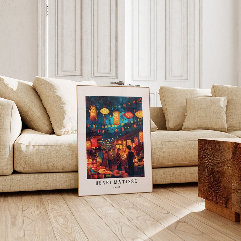 May include: A framed print of a painting depicting a night market scene with colourful lanterns and people walking through the market. The artist's name, Henri Matisse, and the city, Paris, are printed at the bottom of the print.