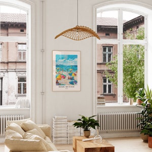 May include: A framed poster of a beach scene with colorful umbrellas and people. The poster is titled "Henri Matisse, Paris".