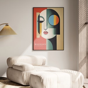 Puede incluir: Un p&oacute;ster enmarcado con un dise&ntilde;o geom&eacute;trico de una cara en tonos de rojo, verde, azul, amarillo y negro. El p&oacute;ster tiene el texto "BAUHAUS" en letras blancas.