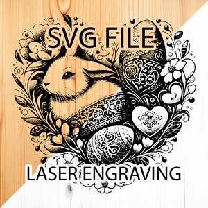 Puede incluir: Ilustración digital en blanco y negro de un conejo con una cesta de huevos, rodeado de flores y hojas. El texto "SVG FILE" y "LASER ENGRAVING" está incluido en la imagen.