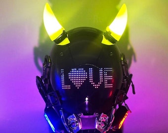 May include: A black helmet with yellow devil horns and a red heart with the word "LOVE" displayed on the front. The helmet is sitting on a stand with a blue, red, and purple background.
