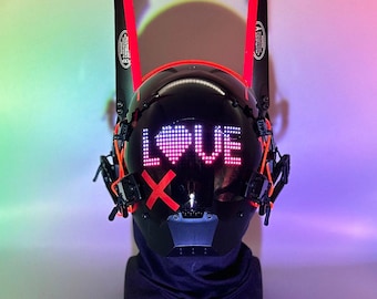 May include: A black helmet with red accents and a visor displaying the word "LOVE" in pink and red LED lights. The helmet is on a black stand.
