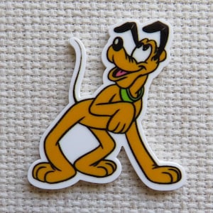May include: A cartoon image of Pluto, a yellow dog with black ears, a green collar, and a white tail. The dog is smiling with its tongue out. The image has a white border and is set against a textured, off-white background.