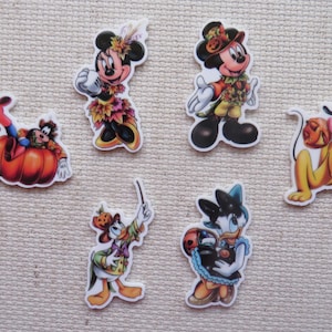 May include: Six colorful iron-on patches featuring Disney characters dressed in fall-themed outfits. The characters include Mickey Mouse, Minnie Mouse, Donald Duck, Goofy, and Pluto.
