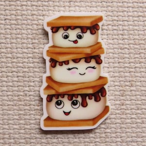 May include: A stack of three smiling s'mores with chocolate and graham crackers. Each marshmallow has googly eyes and a happy expression.