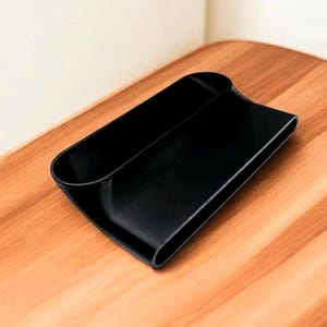 Puede incluir: Un organizador de pl&aacute;stico negro con dos compartimentos. El organizador est&aacute; dise&ntilde;ado para guardar objetos como bol&iacute;grafos, l&aacute;pices u otros objetos peque&ntilde;os.