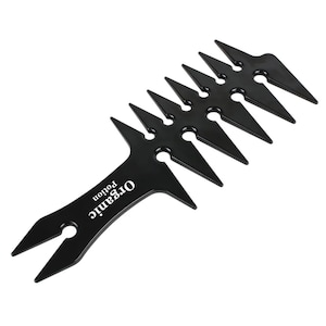 Puede incluir: Peine de plástico negro con un mango puntiagudo y una fila de dientes afilados. El mango tiene el texto "Organic Potion" impreso.