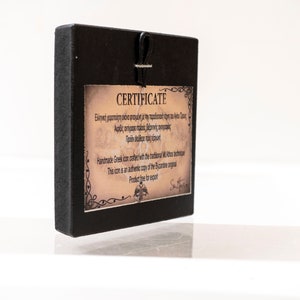 May include: A black wooden frame with a certificate of authenticity for a handmade Greek icon. The certificate is printed on parchment paper with a decorative border and includes the text "&Epsilon;&lambda;&lambda;&eta;&nu;&iota;&kappa;ή &chi;&epsilon;&iota;&rho;&omicron;&pi;&omicron;ί&eta;&tau;&eta; &epsilon;&iota;&kappa;ό&nu;&alpha; &mu;&iota;&mu;έ&nu;&eta; &mu;&epsilon; &tau;&eta; &pi;&rho;&omicron;ϊ&sigma;&tau;&omicron;ή έ&chi;&eta; &tau;&iota; &kappa;&alpha;&iota; &tau;&alpha;&sigmaf;" and "This icon is an authentic copy of the Byzantine original".