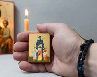 May include: A small wooden icon depicting the Virgin Mary and Child with three saints. The icon is painted in a traditional style with gold accents and is held in a person's hand.