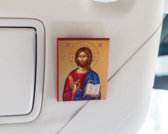 May include: A small, framed icon of Jesus Christ with a red and blue robe, holding a book. The icon is set against a gold background with the text "IC XC" in the top corners.