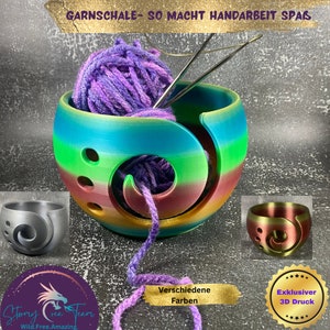 Könnte beinhalten: Eine regenbogenfarbene Garn-Schale mit einer lila Garnkugel und Stricknadeln. Die Schale hat ein Spiraldesign und Löcher, durch die das Garn geführt werden kann. Der Text "GARNSCHALE- SO MACHT HANDARBEIT SPAS" befindet sich oben im Bild. Der Text "Verschiedene Farben" befindet sich unten im Bild. Der Text "Exklusiver 3D Druck" befindet sich unten rechts im Bild.