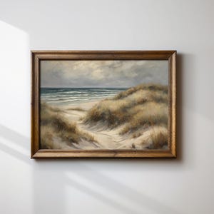 Peut inclure: Une peinture encadrée représentant un paysage maritime avec un chemin menant à travers des dunes de sable jusqu'à l'océan. Le ciel est nuageux et l'eau est bleu clair. Les dunes de sable sont recouvertes d'herbes brunes et vertes.