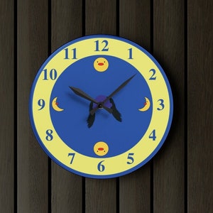 Puede incluir: Un reloj azul y amarillo con un dise&ntilde;o de luna y sol. La esfera del reloj tiene agujas negras y los n&uacute;meros del 1 al 12 est&aacute;n impresos en blanco.