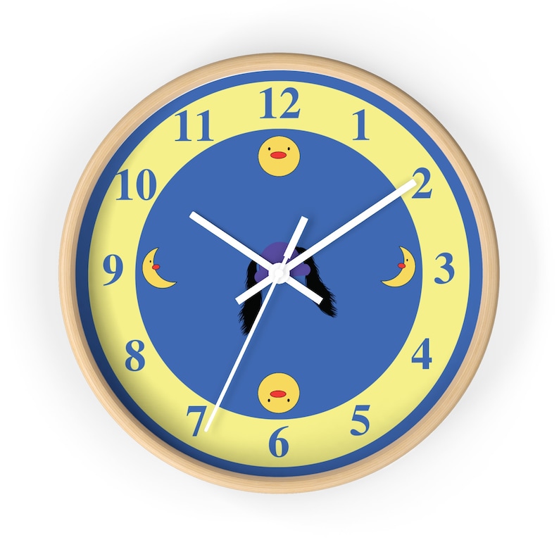 Puede incluir: Un reloj de pared azul y amarillo con una esfera y agujas blancas. El reloj tiene un dise&ntilde;o de pato y luna de dibujos animados. Los n&uacute;meros del 1 al 12 se muestran alrededor de la esfera del reloj.