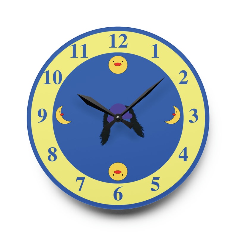 Puede incluir: Un reloj azul y amarillo con manecillas negras y una cara de pato de dibujos animados en el 12. La esfera del reloj tiene un anillo exterior amarillo con n&uacute;meros negros y un c&iacute;rculo interior azul con una luna de dibujos animados y caras de pato.