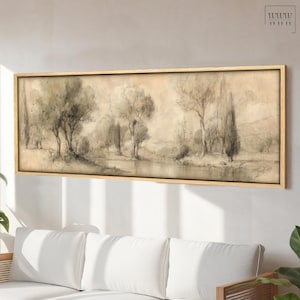 Könnte beinhalten: Ein gerahmter Landschaftskunst-Druck mit einer ruhigen Szene mit Bäumen, einem Gewässer und einer sanften, neutralen Farbpalette. Das Kunstwerk ist in einem hellfarbigen Holzrahmen eingefasst, der dem Stück eine natürliche Wärme verleiht.