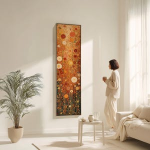 Puede incluir: Obra de arte abstracta vertical enmarcada. La pintura utiliza una paleta de colores cálidos de naranja, amarillo y rojo, con formas circulares y lineales. La obra se exhibe en una pared blanca en una habitación luminosa. El marco es dorado.