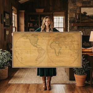 Op de afbeelding: Een groot rechthoekig wandkunstwerk met een wereldkaart in vintage-stijl op een sepia-kleurige achtergrond. De kaart toont twee cirkelvormige hemisferen met gedetailleerde geografische contouren, landmassa's en oceanen, voorzien van de tekst WORLD.
