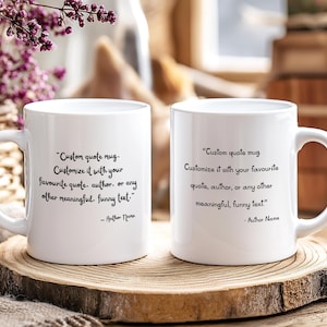 May include: Two white ceramic mugs with a custom quote printed in black. The text reads: "Custom quote mug. Customize it with your favourite quote, author, or any other meaningful, funny text." The mugs are on a wooden surface.