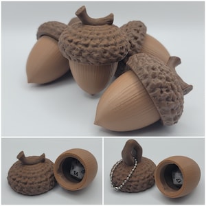 May include: Three brown acorn-shaped dice holders with a textured surface. Each holder has a small opening on the top to insert a die. The holders are arranged in a row on a white surface.