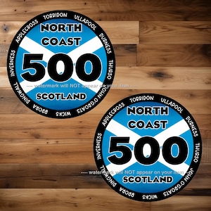 Può includere: Due adesivi rotondi blu e bianchi con il testo "North Coast 500" in nero. Gli adesivi presentano un design di bandiera scozzese stilizzato e il testo "Scotland" in nero. Il testo "watermark will NOT appear on your item" è stampato in grigio sotto gli adesivi.